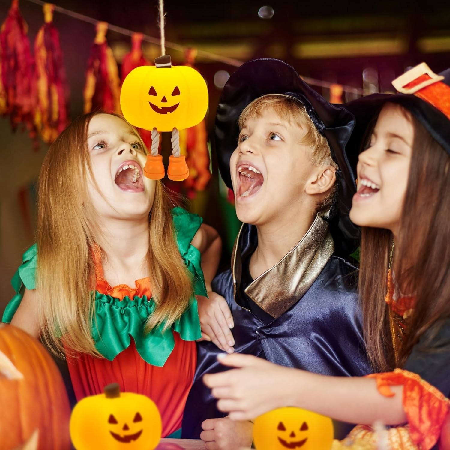 Children in Halloween costumes with pumpkins and decorations, celebrating a festive occasion.